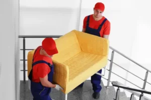 two-male-workers-with-yellow-couch-staircases_392895-223222